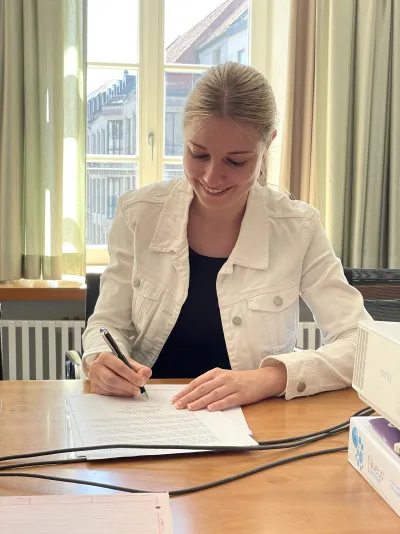 Kundin von CDL Immobilien während der Vertragsunterschrift beim Notar in München.